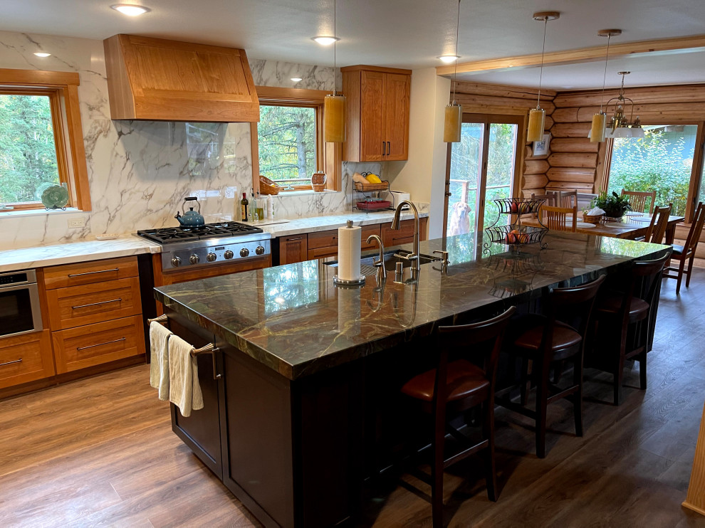 Large mountain style l-shaped vinyl floor and brown floor eat-in kitchen photo with an undermount sink, shaker cabinets, light wood cabinets, quartzite countertops, white backsplash, porcelain backsplash, stainless steel appliances, an island and green countertops