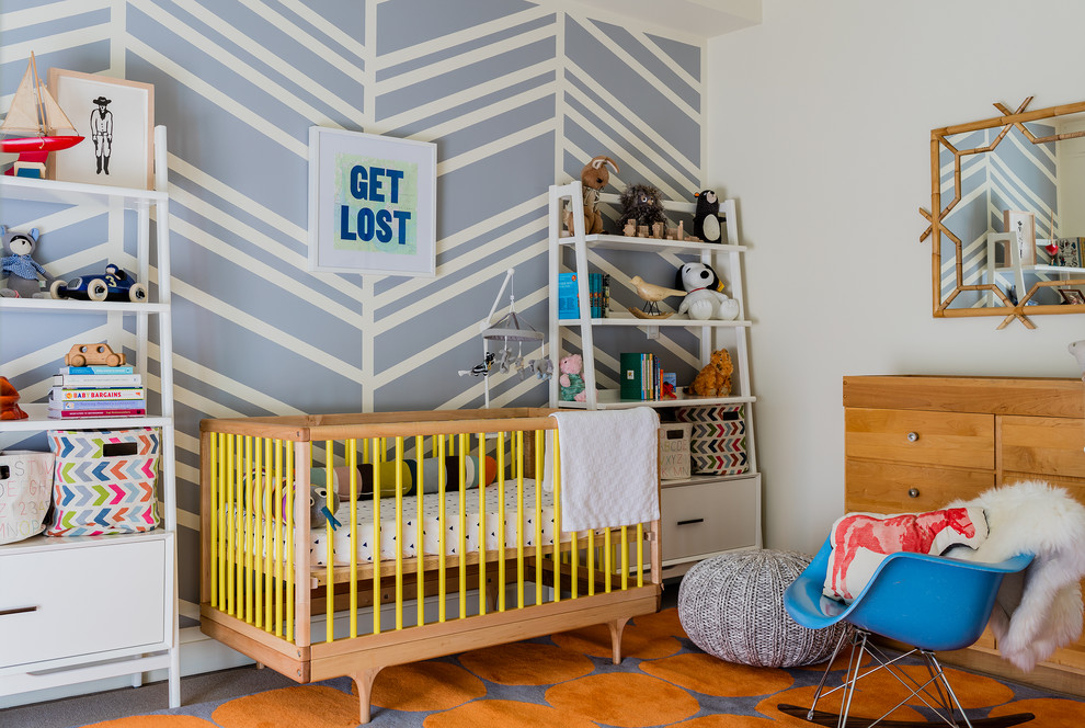 Imagen de habitación de bebé neutra contemporánea con paredes multicolor y suelo naranja