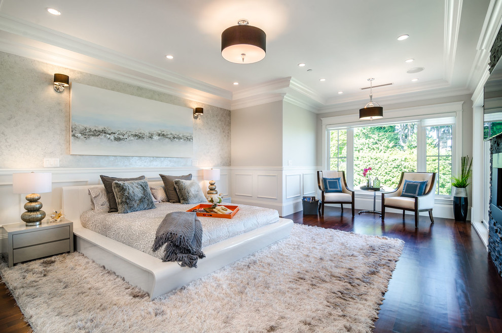 Design ideas for a transitional master bedroom in Vancouver with grey walls, dark hardwood floors, a ribbon fireplace and a stone fireplace surround.