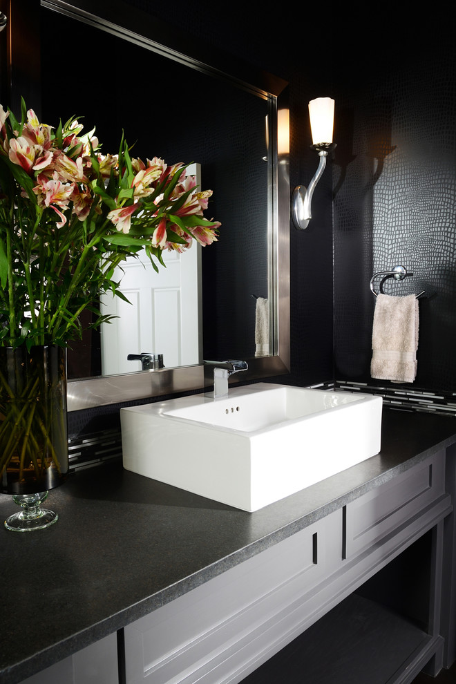 Photo of a small traditional powder room in Other with a vessel sink, grey cabinets, black tile, black walls, engineered quartz benchtops, recessed-panel cabinets and black benchtops.