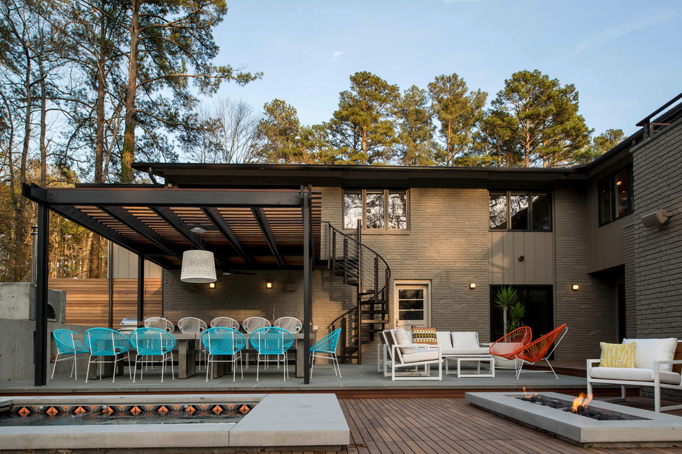 Photo of a midcentury backyard patio in Raleigh with a pergola and decking.