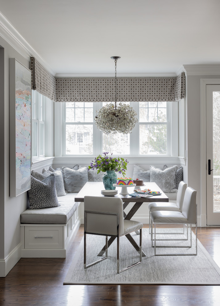 Design ideas for a classic dining room in Boston with banquette seating, grey walls, brown floors and dark hardwood flooring.