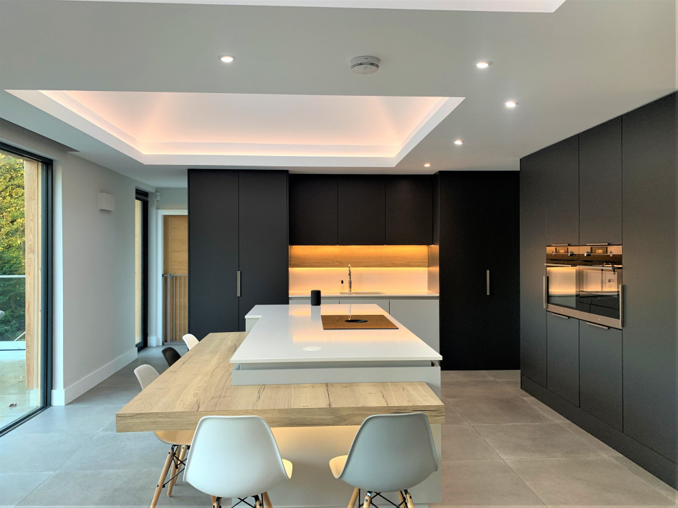 Design ideas for a large contemporary l-shaped eat-in kitchen in Other with a single-bowl sink, flat-panel cabinets, light wood cabinets, quartzite benchtops, black appliances, vinyl floors, with island, grey floor and white benchtop.
