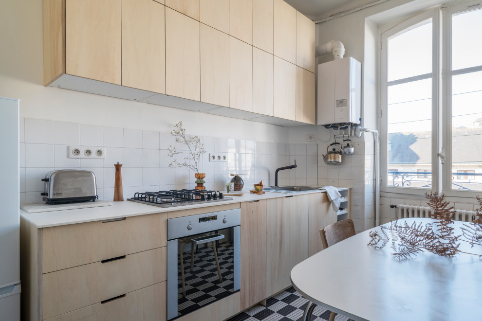 Inspiration for a small scandinavian single-wall separate kitchen in Nantes with a single-bowl sink, flat-panel cabinets, light wood cabinets, laminate benchtops, white splashback, ceramic splashback, stainless steel appliances, ceramic floors, no island and white benchtop.