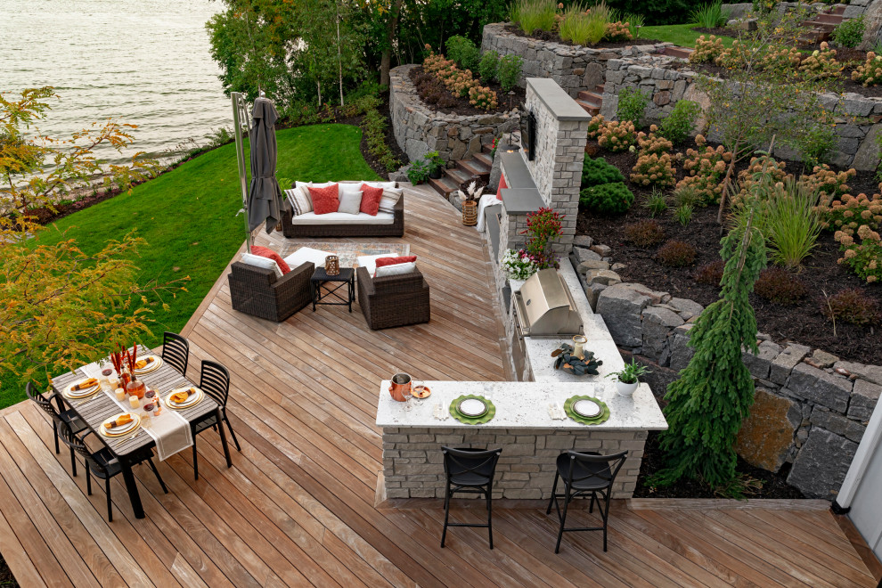 Design ideas for a large beach style backyard partial sun garden for summer in Minneapolis with a retaining wall and decking.