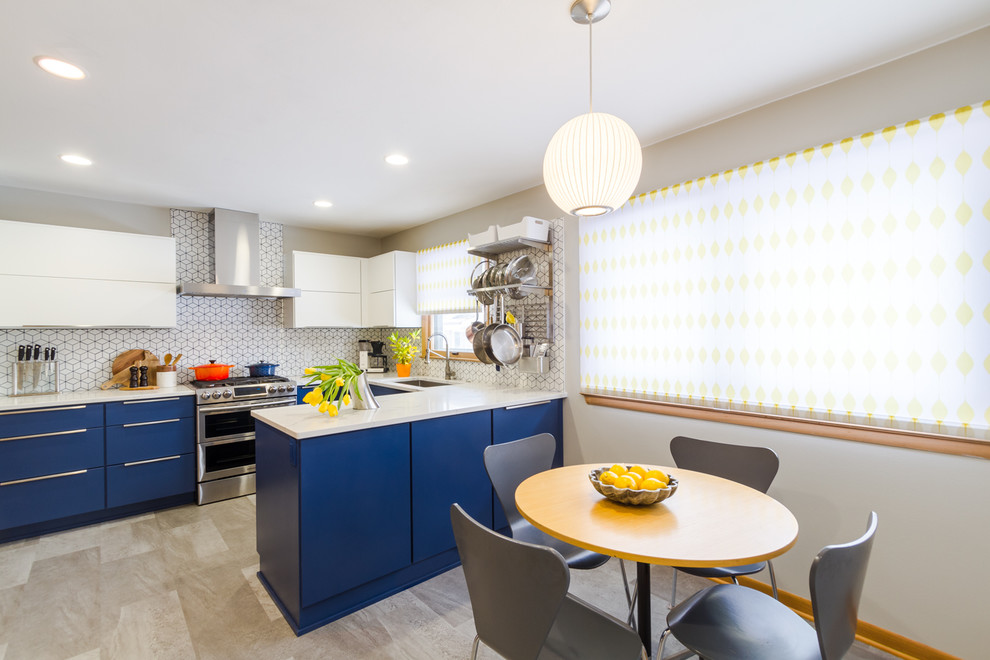 This is an example of a mid-sized midcentury u-shaped separate kitchen in Milwaukee with an undermount sink, flat-panel cabinets, blue cabinets, quartz benchtops, white splashback, ceramic splashback, stainless steel appliances, cement tiles, a peninsula, grey floor and white benchtop.