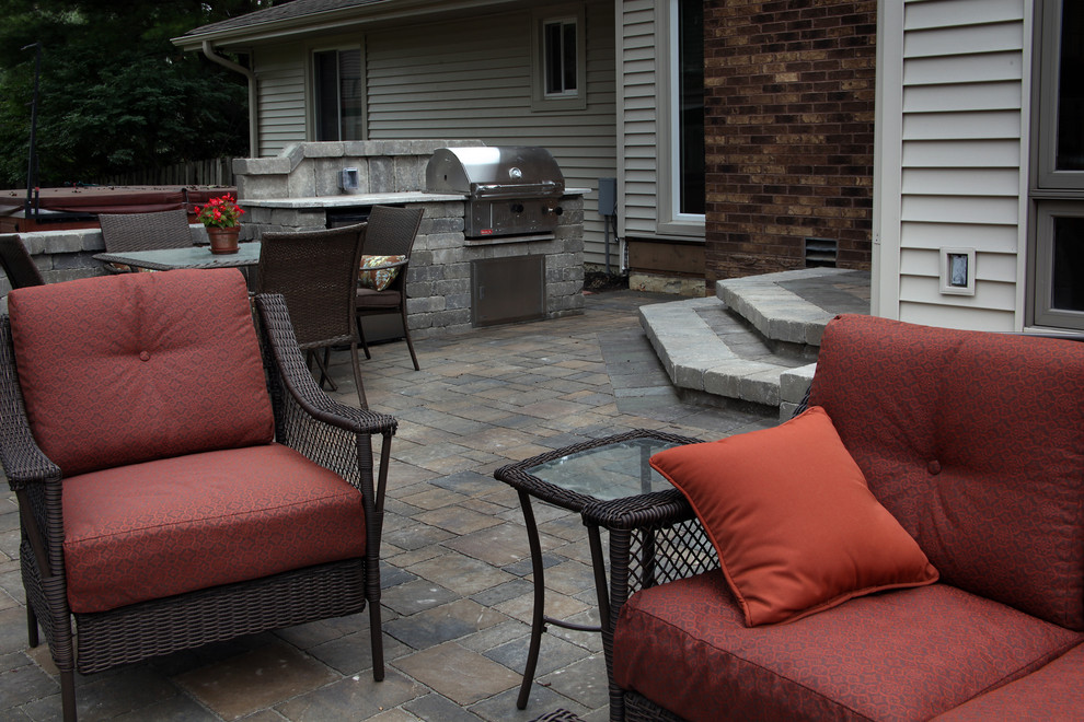 Inspiration for a large traditional backyard patio in Omaha with a fire feature, concrete pavers and no cover.