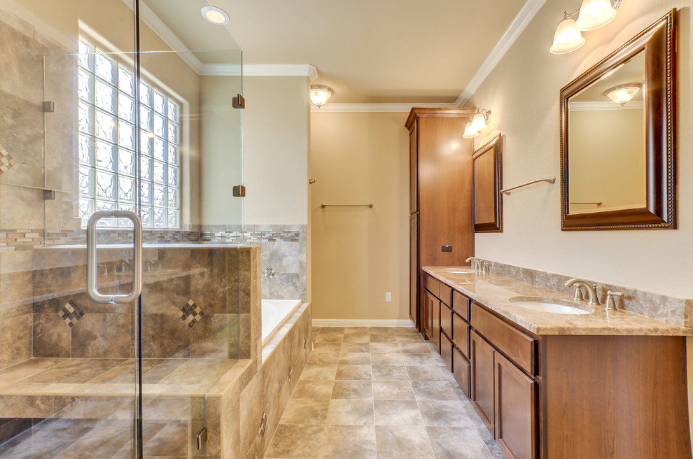 This is an example of a traditional master bathroom in Austin with recessed-panel cabinets, medium wood cabinets, a drop-in tub, a corner shower, beige tile, gray tile, multi-coloured tile, ceramic tile, beige walls, linoleum floors, an undermount sink, granite benchtops, brown floor and a hinged shower door.