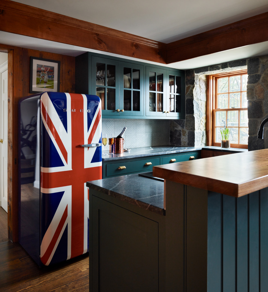 Medium sized classic galley open plan kitchen in Boston with a submerged sink, glass-front cabinets, green cabinets, soapstone worktops, black splashback, stone slab splashback, medium hardwood flooring, brown floors, black worktops and a coffered ceiling.