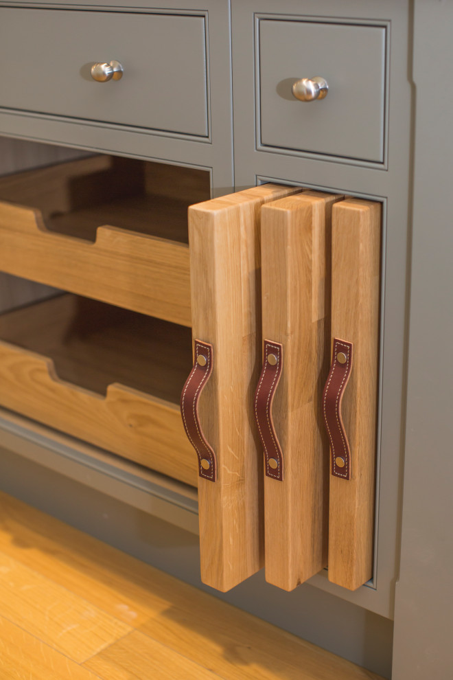 Design ideas for a medium sized contemporary l-shaped enclosed kitchen in Other with a belfast sink, shaker cabinets, green cabinets, quartz worktops, white splashback, stone slab splashback, coloured appliances, medium hardwood flooring, an island, brown floors, white worktops and a chimney breast.