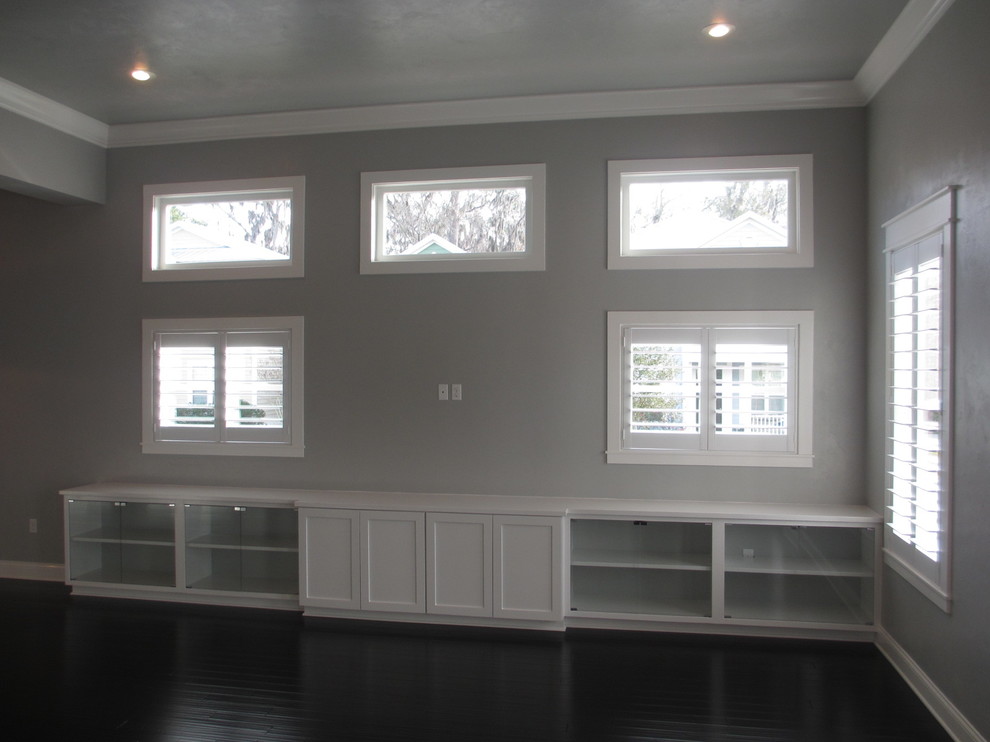 This is an example of a mid-sized asian open concept family room in Miami with grey walls and a wall-mounted tv.