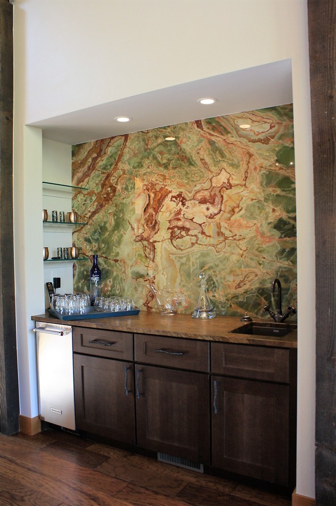 Mid-sized mountain style vinyl floor home bar photo with an undermount sink, granite countertops, green backsplash and stone tile backsplash
