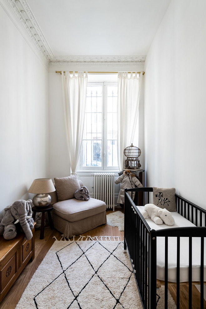 Inspiration for a transitional nursery in Bordeaux with white walls, medium hardwood floors and brown floor.