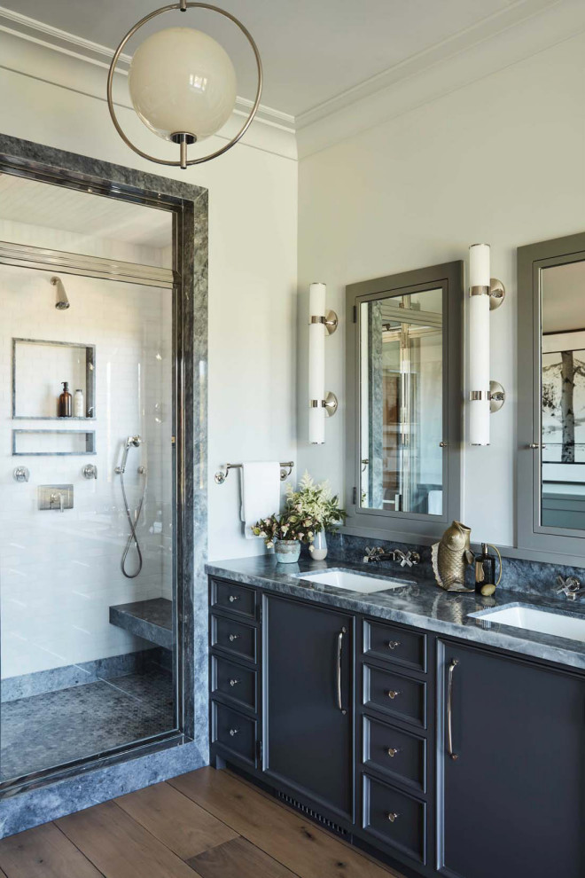 Inspiration for a transitional bathroom in Los Angeles with recessed-panel cabinets, grey cabinets, an alcove shower, white walls, medium hardwood floors, an undermount sink, brown floor, a hinged shower door, grey benchtops, a niche, a shower seat, a double vanity and a built-in vanity.
