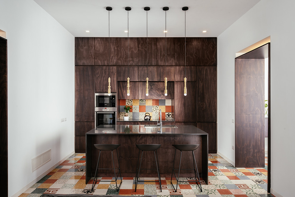 Photo of a contemporary single-wall kitchen in Naples with dark wood cabinets, quartz benchtops, cement tile splashback, stainless steel appliances, cement tiles, with island, an undermount sink, flat-panel cabinets, multi-coloured splashback, multi-coloured floor and brown benchtop.