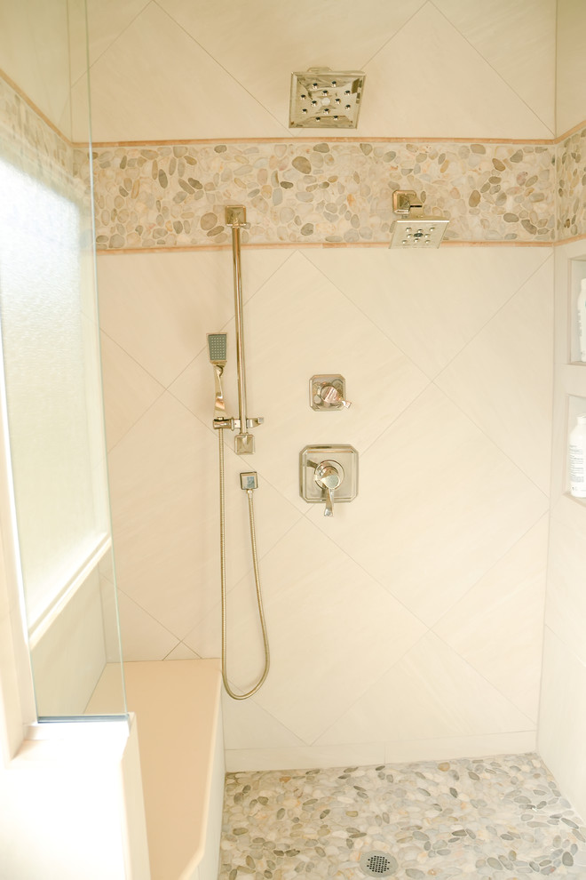 Photo of a transitional master bathroom in St Louis with recessed-panel cabinets, beige cabinets, a drop-in tub, a corner shower, a two-piece toilet, beige tile, white tile, porcelain tile, beige walls, porcelain floors, a drop-in sink and solid surface benchtops.