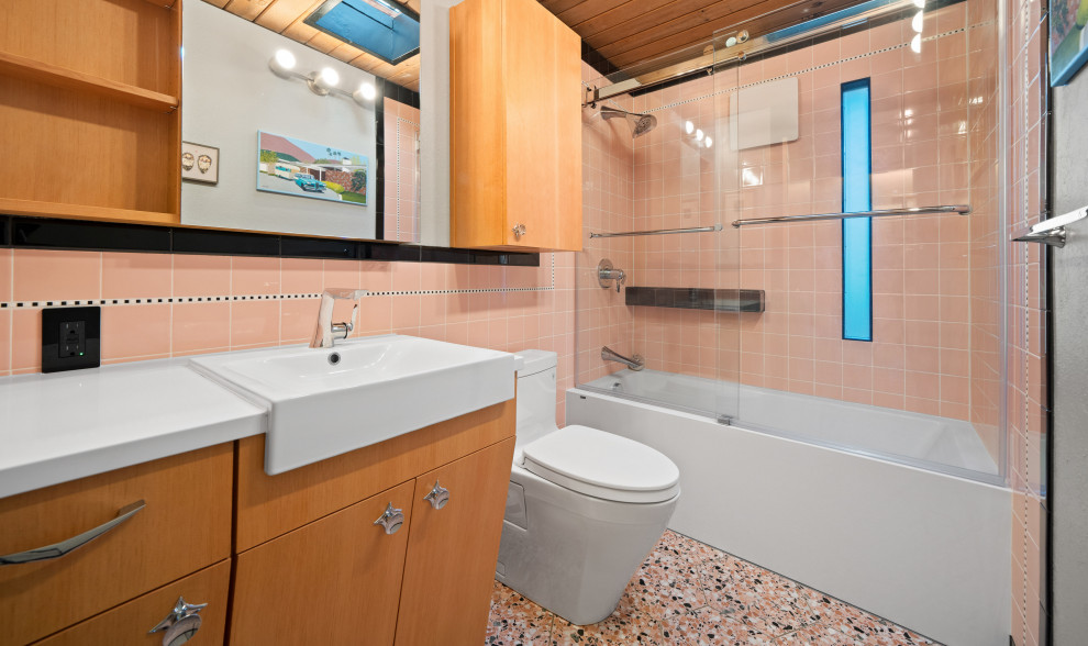 Стильный дизайн: ванная комната в стиле ретро с фасадами цвета дерева среднего тона, накладной ванной, душем над ванной, унитазом-моноблоком, розовой плиткой, керамической плиткой, разноцветными стенами, полом из керамогранита, душевой кабиной, накладной раковиной, столешницей из кварцита, серым полом, душем с раздвижными дверями, белой столешницей, тумбой под одну раковину и встроенной тумбой - последний тренд