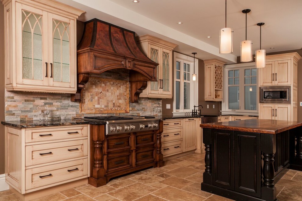 This is an example of a mid-sized traditional u-shaped open plan kitchen in Toronto with a farmhouse sink, recessed-panel cabinets, dark wood cabinets, beige splashback, stone tile splashback, stainless steel appliances and with island.