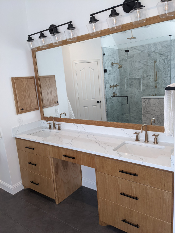 This is an example of a large modern master bathroom in Houston with flat-panel cabinets, medium wood cabinets, a freestanding tub, a curbless shower, a bidet, white tile, marble, grey walls, porcelain floors, an undermount sink, engineered quartz benchtops, grey floor, a hinged shower door, yellow benchtops, a shower seat, a double vanity and a built-in vanity.
