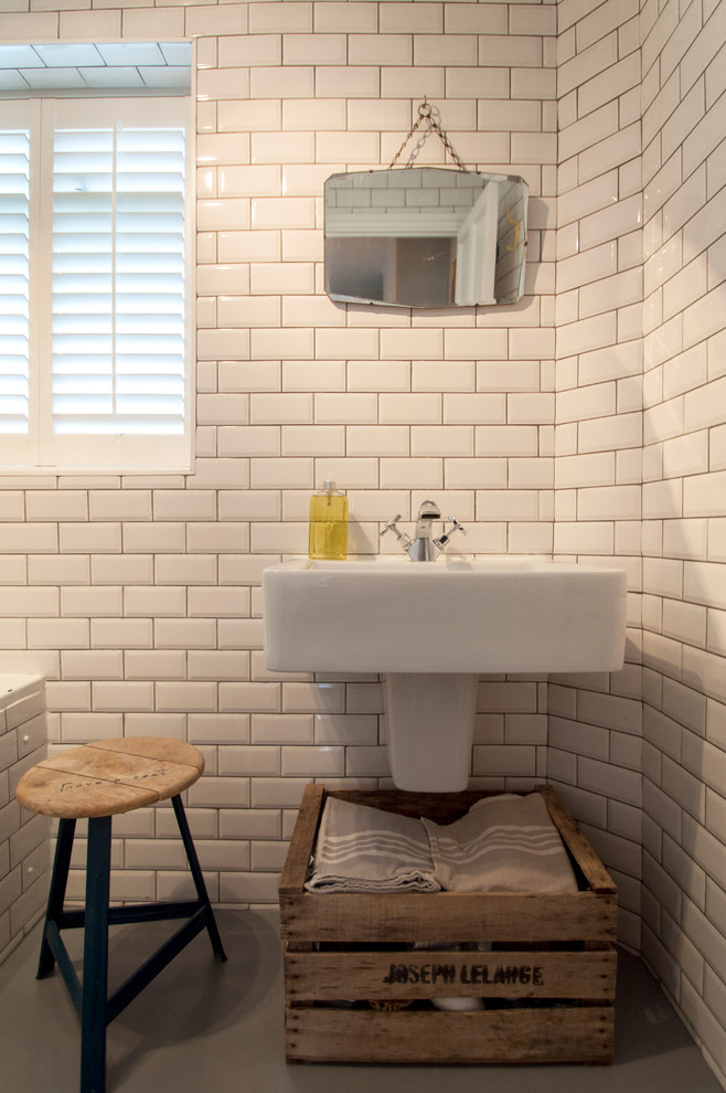 Eclectic bathroom in London with a wall-mount sink and subway tile.