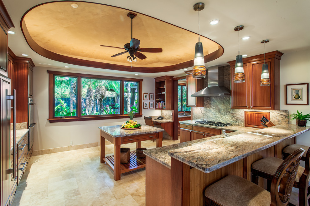 Inspiration for a large tropical u-shaped kitchen in Hawaii with a double-bowl sink, raised-panel cabinets, dark wood cabinets, granite benchtops, stainless steel appliances, travertine floors, with island, grey splashback and stone slab splashback.