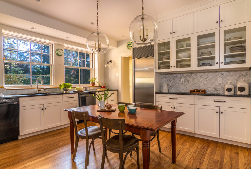 Large transitional u-shaped eat-in kitchen in Boston with shaker cabinets, white cabinets, no island, an undermount sink, solid surface benchtops, grey splashback, mosaic tile splashback, stainless steel appliances, medium hardwood floors and brown floor.