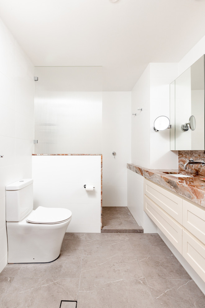 Mid-sized contemporary master bathroom in Sydney with shaker cabinets, beige cabinets, an open shower, a one-piece toilet, white tile, ceramic tile, white walls, ceramic floors, an undermount sink, marble benchtops, grey floor, pink benchtops, a double vanity and a floating vanity.
