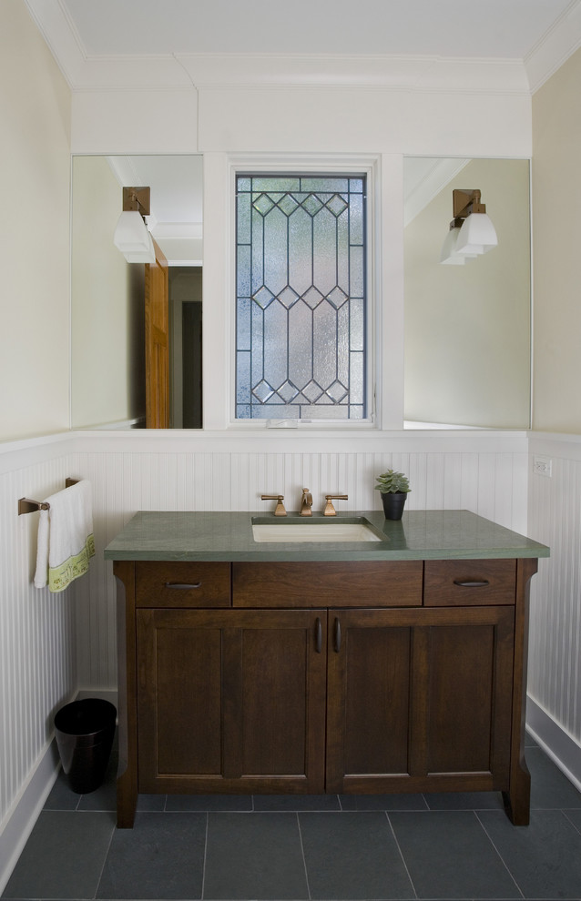 This is an example of a mid-sized arts and crafts powder room in Chicago with an undermount sink, shaker cabinets, dark wood cabinets, green benchtops, a two-piece toilet, beige walls, slate floors, granite benchtops, green floor, a freestanding vanity and panelled walls.