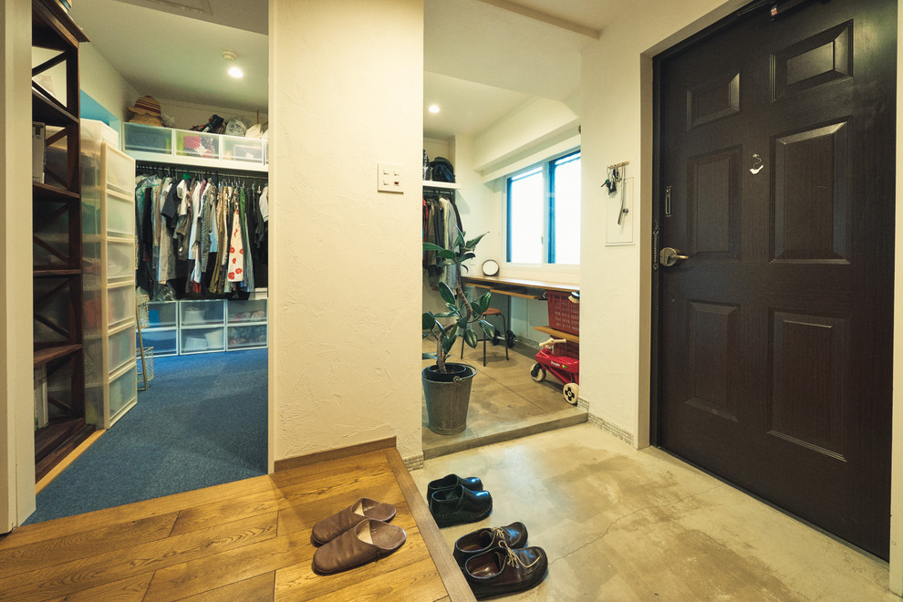 Contemporary mudroom in Nagoya with white walls, concrete floors, a single front door and a dark wood front door.