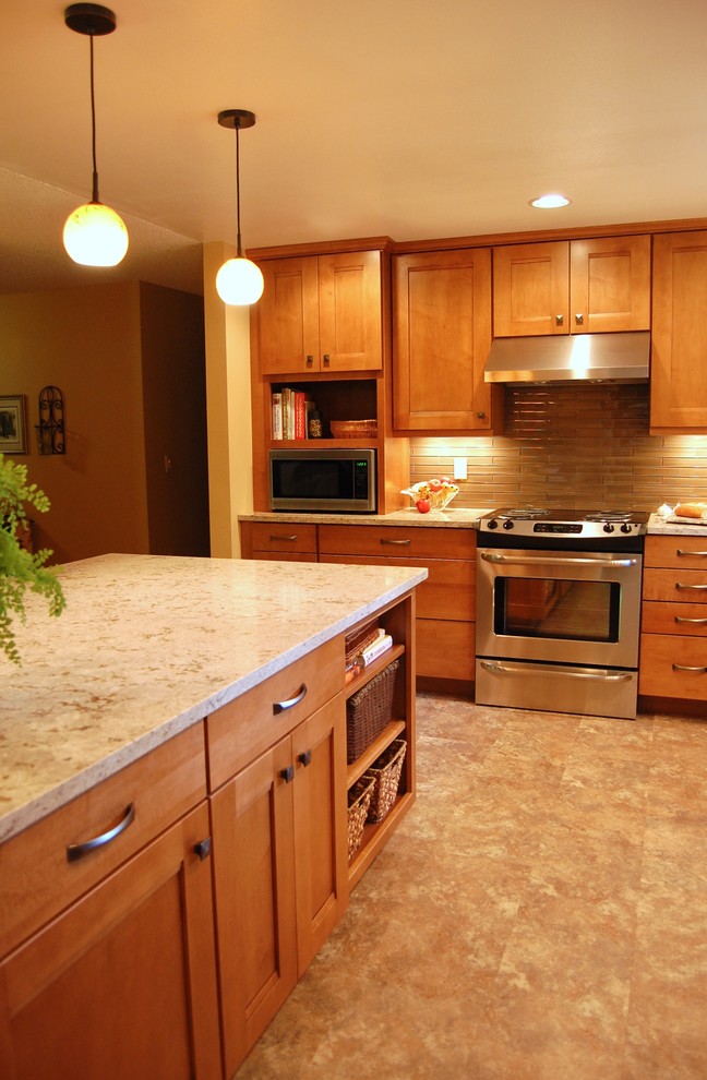 Open concept kitchen - mid-sized transitional l-shaped laminate floor open concept kitchen idea in Portland with an undermount sink, shaker cabinets, medium tone wood cabinets, quartz countertops, brown backsplash, glass tile backsplash, stainless steel appliances, a peninsula and multicolored countertops