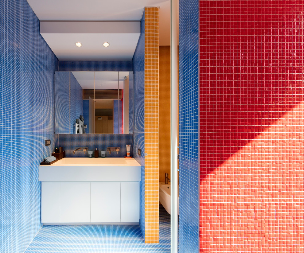 Пример оригинального дизайна: огромная детская ванная комната в стиле модернизм с белыми фасадами, разноцветной плиткой, плиткой мозаикой, разноцветными стенами, полом из мозаичной плитки, монолитной раковиной, синим полом, белой столешницей и тумбой под две раковины