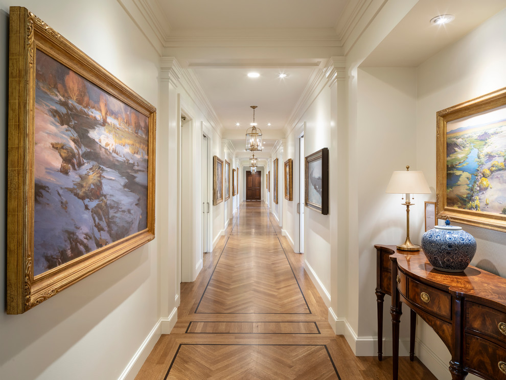 This is an example of a traditional hallway in Salt Lake City with white walls, medium hardwood floors and brown floor.