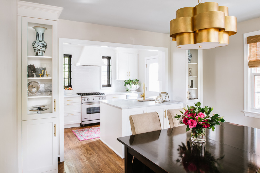 Photo of a small transitional galley eat-in kitchen in DC Metro with a farmhouse sink, shaker cabinets, white cabinets, marble benchtops, white splashback, ceramic splashback, stainless steel appliances, medium hardwood floors and no island.