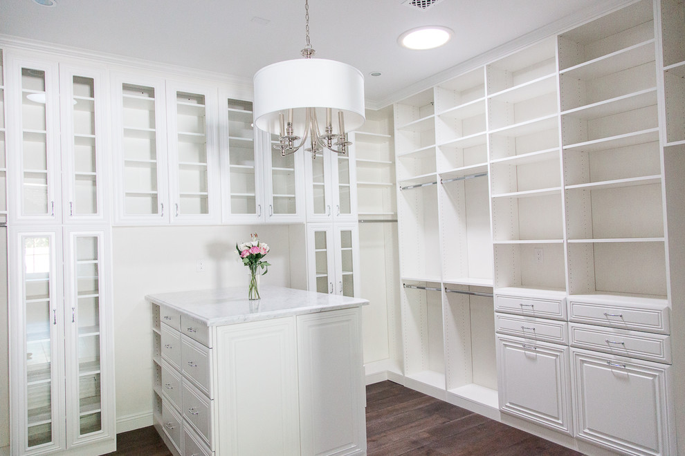 Mid-sized elegant gender-neutral medium tone wood floor walk-in closet photo in Phoenix with raised-panel cabinets and white cabinets