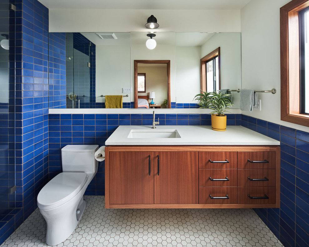 Foto på ett mellanstort 50 tals vit badrum för barn, med släta luckor, skåp i mellenmörkt trä, en dusch i en alkov, blå kakel, keramikplattor, bänkskiva i kvarts och dusch med gångjärnsdörr