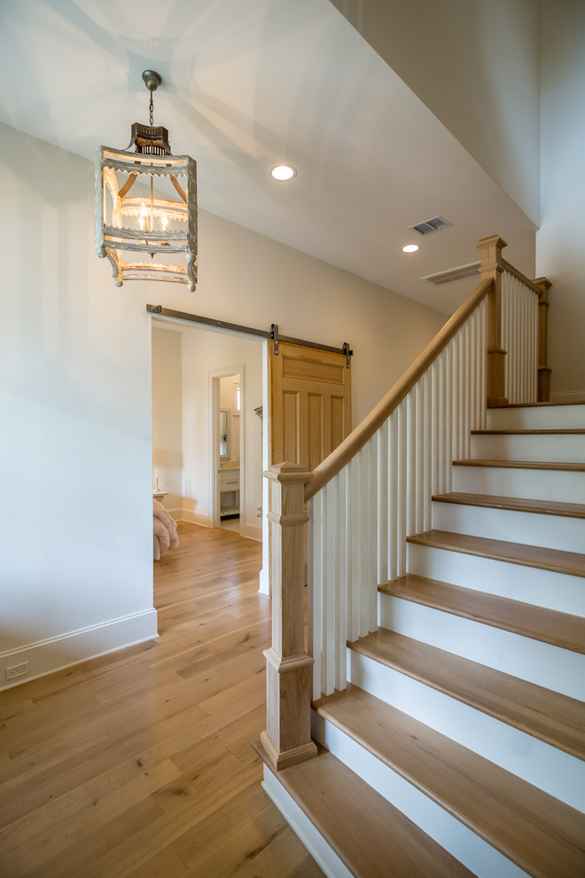 Design ideas for a large country wood u-shaped staircase in New Orleans with wood risers.