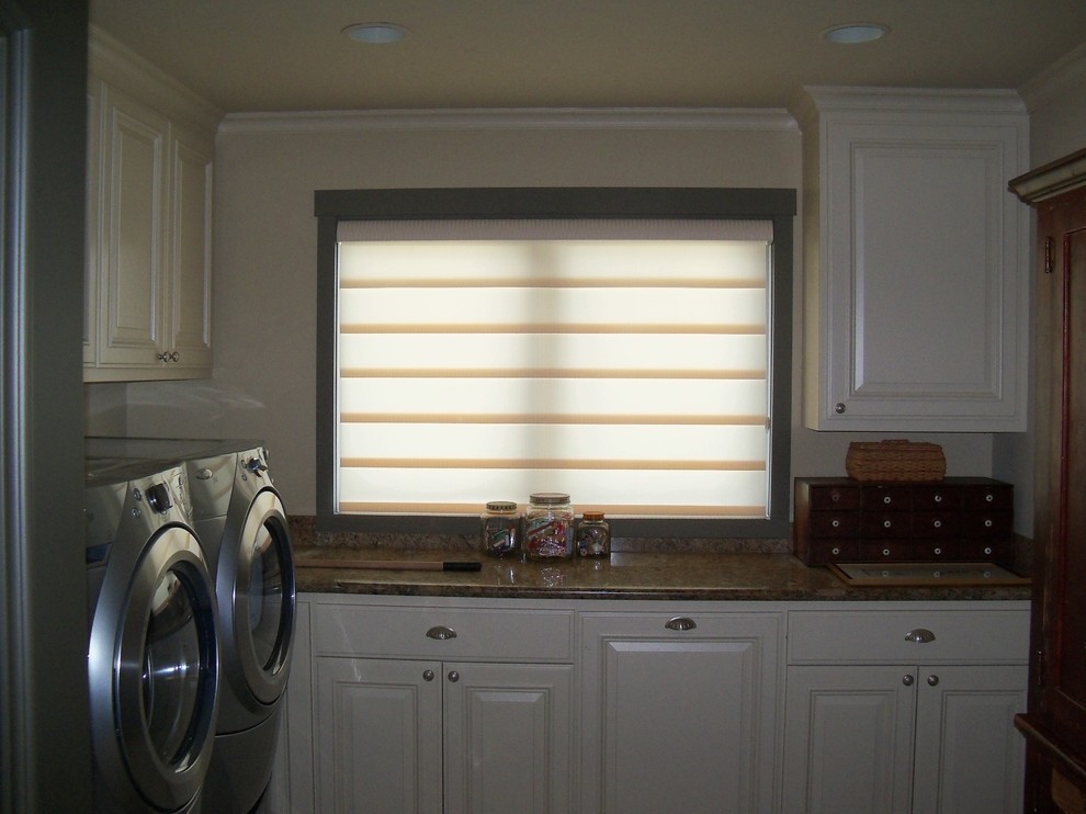 Laundry room - mid-sized traditional laundry room idea with raised-panel cabinets, white cabinets, granite countertops, white walls, a side-by-side washer/dryer and brown countertops
