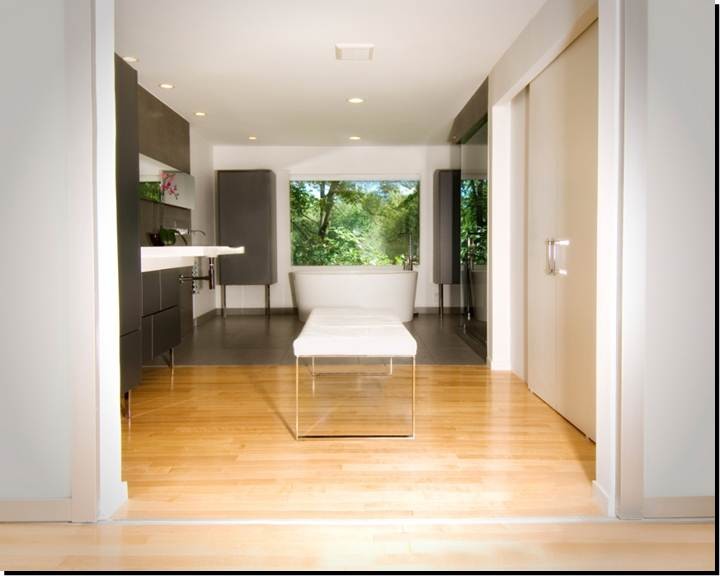 Inspiration for a large modern master bathroom in New York with flat-panel cabinets, grey cabinets, a freestanding tub, a corner shower, beige walls, light hardwood floors, a wall-mount sink and solid surface benchtops.