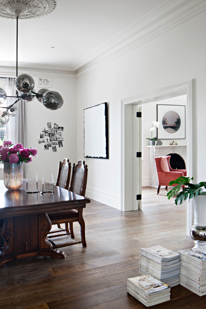 Photo of a scandinavian separate dining room in Melbourne with white walls and dark hardwood floors.