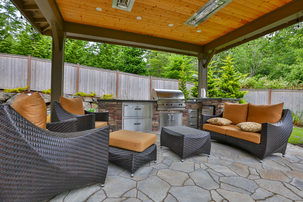 Design ideas for a large modern backyard patio in Seattle with an outdoor kitchen, natural stone pavers and a gazebo/cabana.