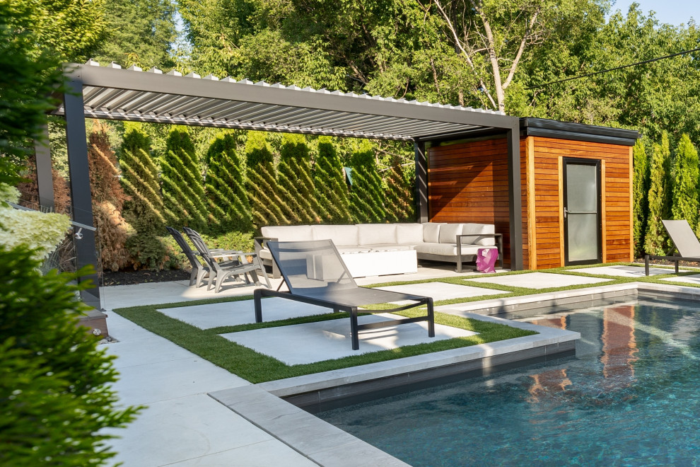На фото: маленький прямоугольный ландшафтный бассейн на заднем дворе в стиле неоклассика (современная классика) с покрытием из декоративного бетона для на участке и в саду