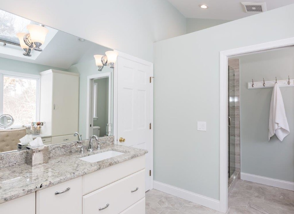 Inspiration for a mid-sized transitional master alcove shower remodel in Boston with furniture-like cabinets, white cabinets, blue walls, an undermount sink, granite countertops and a hinged shower door