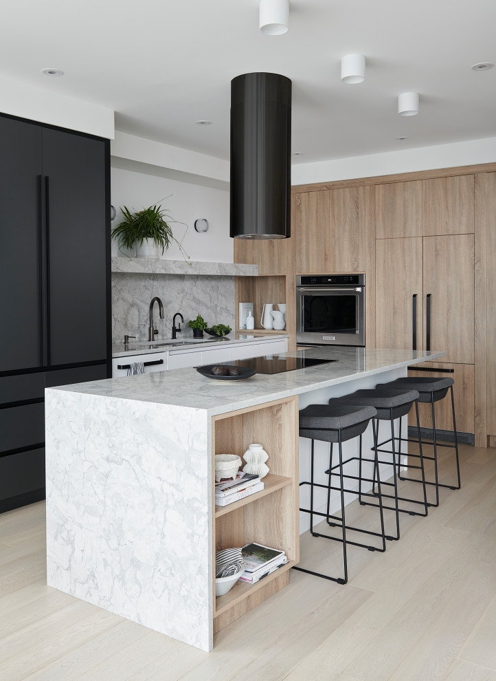 This is an example of a mid-sized contemporary eat-in kitchen in Toronto with a double-bowl sink, flat-panel cabinets, light wood cabinets, quartz benchtops, grey splashback, engineered quartz splashback, stainless steel appliances, light hardwood floors, with island, beige floor and grey benchtop.