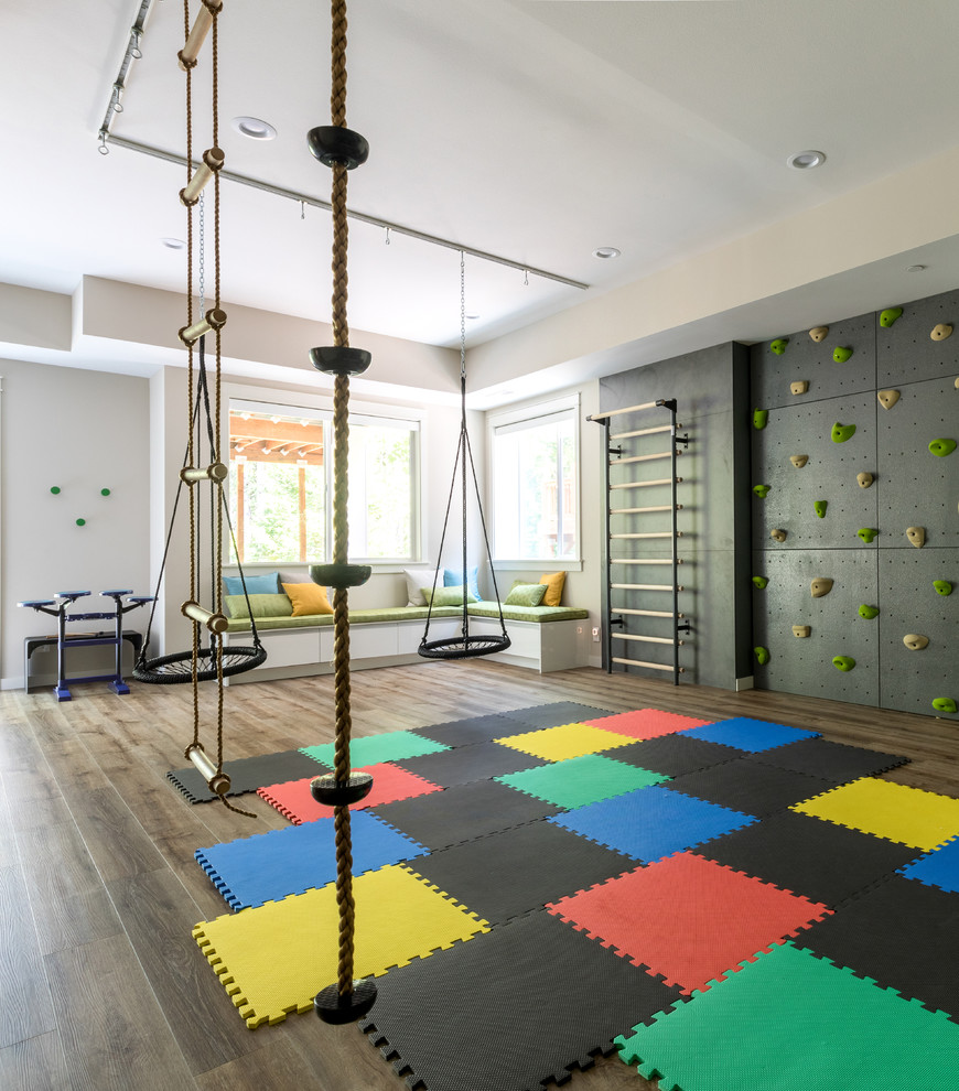 This is an example of an expansive contemporary gender-neutral kids' playroom for kids 4-10 years old in Seattle with black walls, dark hardwood floors and brown floor.