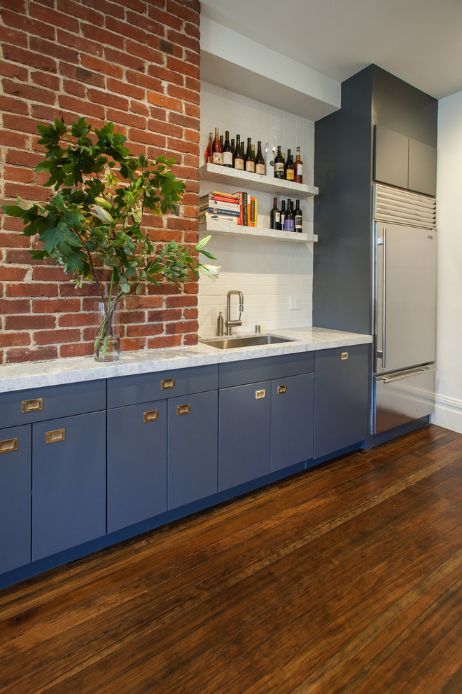Photo of a contemporary kitchen in San Francisco with flat-panel cabinets, stainless steel appliances, subway tile splashback, blue cabinets, white splashback and marble benchtops.