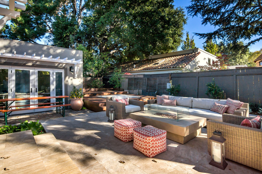 This is an example of a mid-sized transitional backyard patio in San Francisco with a fire feature and natural stone pavers.