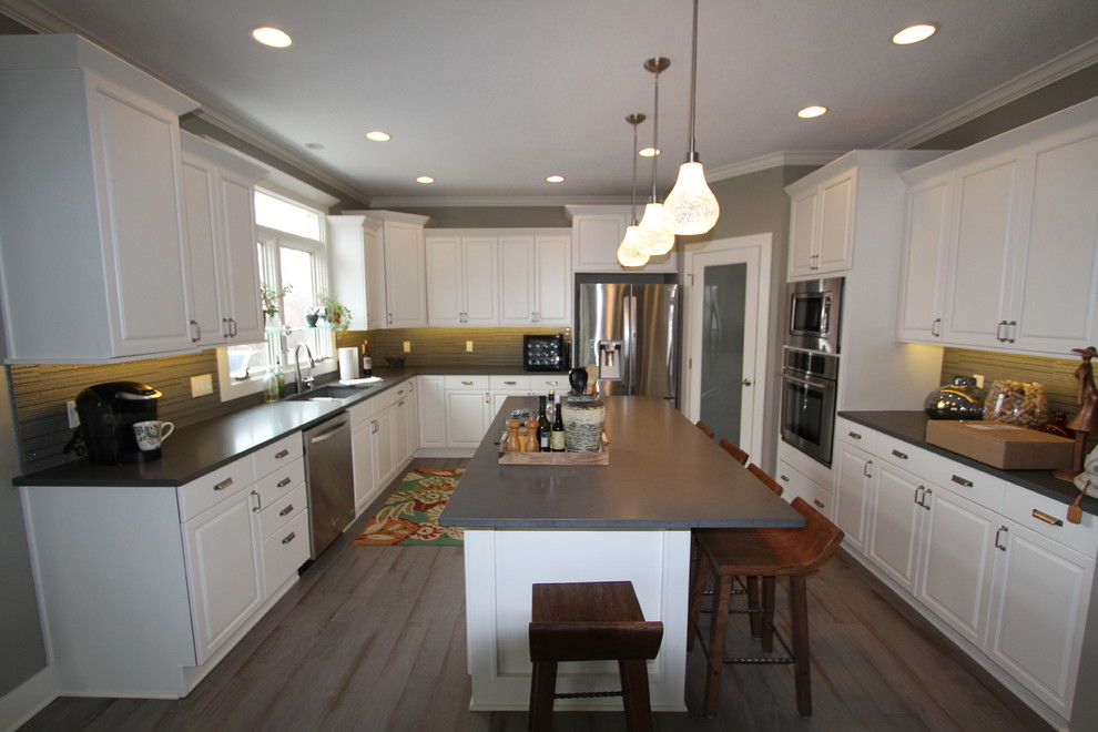 Inspiration for a mid-sized transitional u-shaped medium tone wood floor eat-in kitchen remodel with an undermount sink, white cabinets, quartz countertops, stainless steel appliances and an island