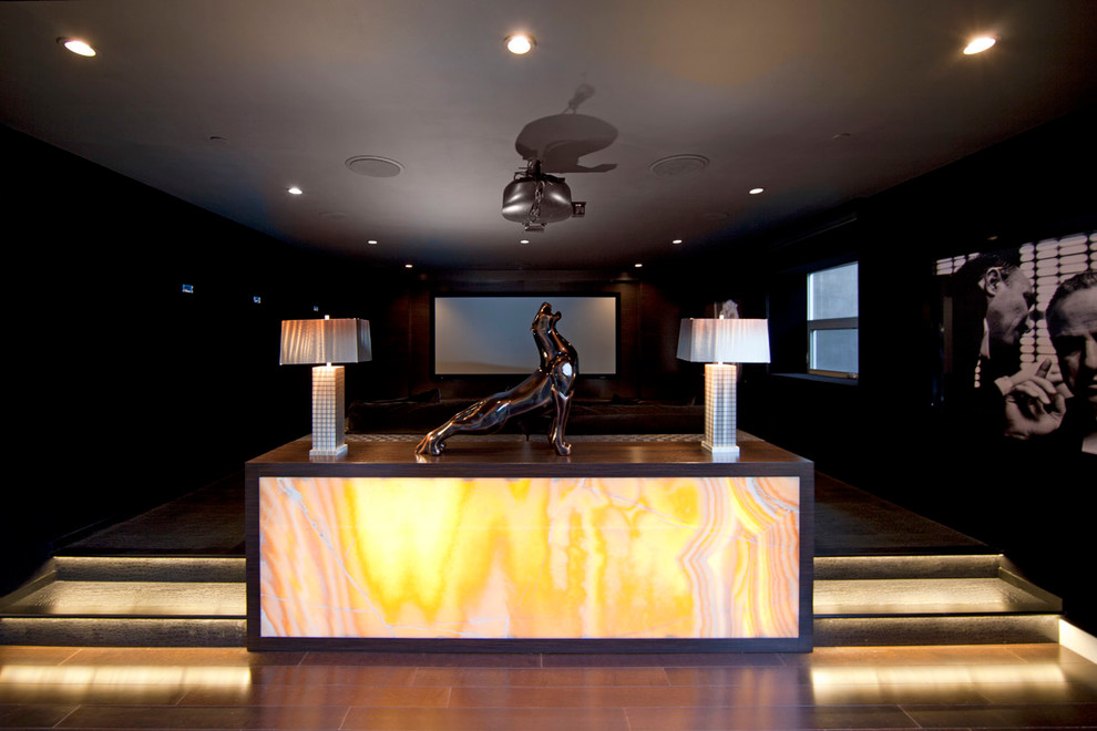 Photo of a large contemporary enclosed home theatre in Los Angeles with grey walls, carpet and a projector screen.