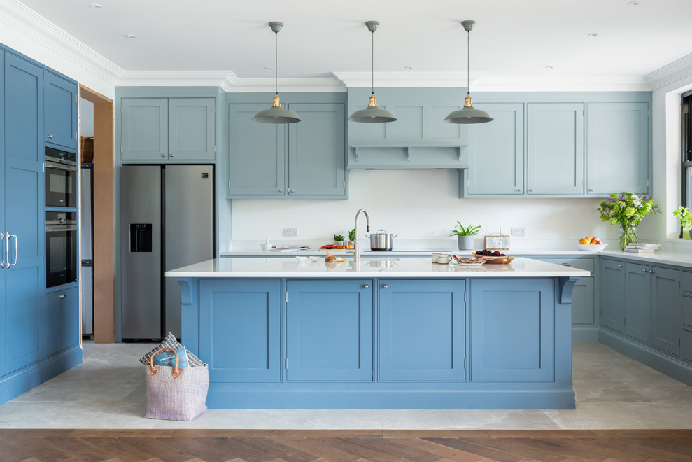 Inspiration for a large beach style u-shaped eat-in kitchen in Surrey with shaker cabinets, blue cabinets, quartzite benchtops, stainless steel appliances, ceramic floors, with island and white benchtop.
