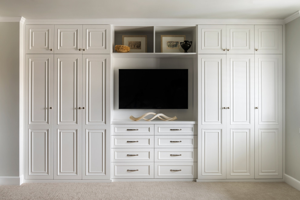 Photo of a mid-sized transitional gender-neutral storage and wardrobe in San Francisco with recessed-panel cabinets, white cabinets, carpet and beige floor.